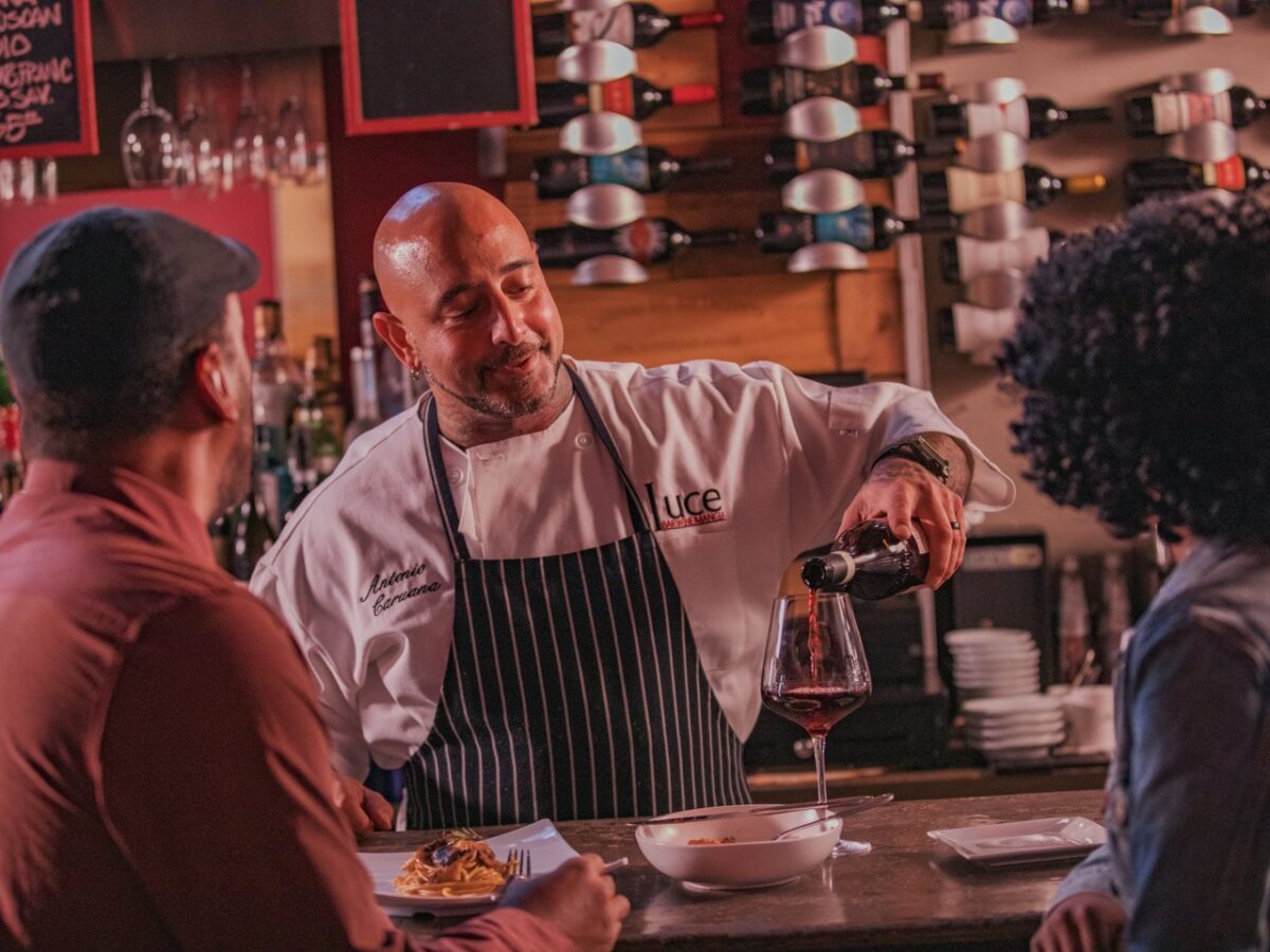 Bartender pouring a glass of wine at Luce, Downtown Norfolk restaurant. 