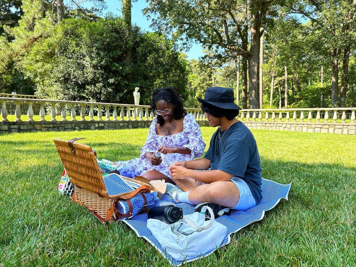 two people sitting on a picnic blanket enjoying a picnic at Norfolk botanical garden